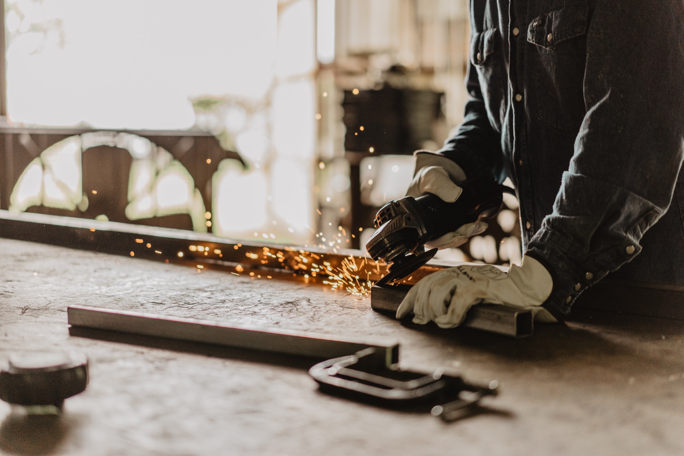Sparks flying as a fabricator grinds a weld, shot on site